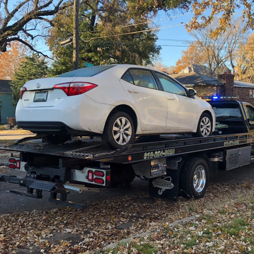 a white car on a flatbed truck