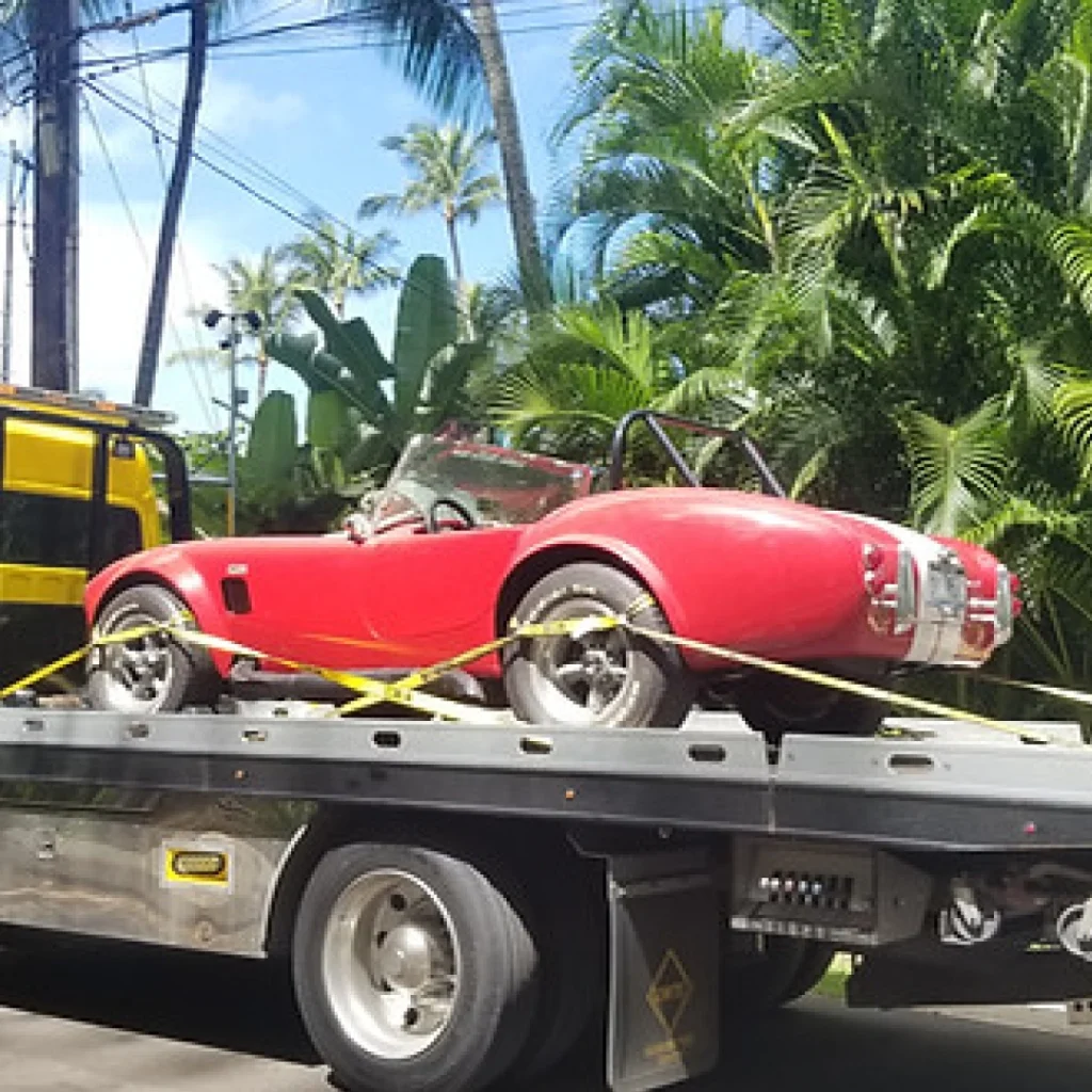 a red car on a flatbed truck