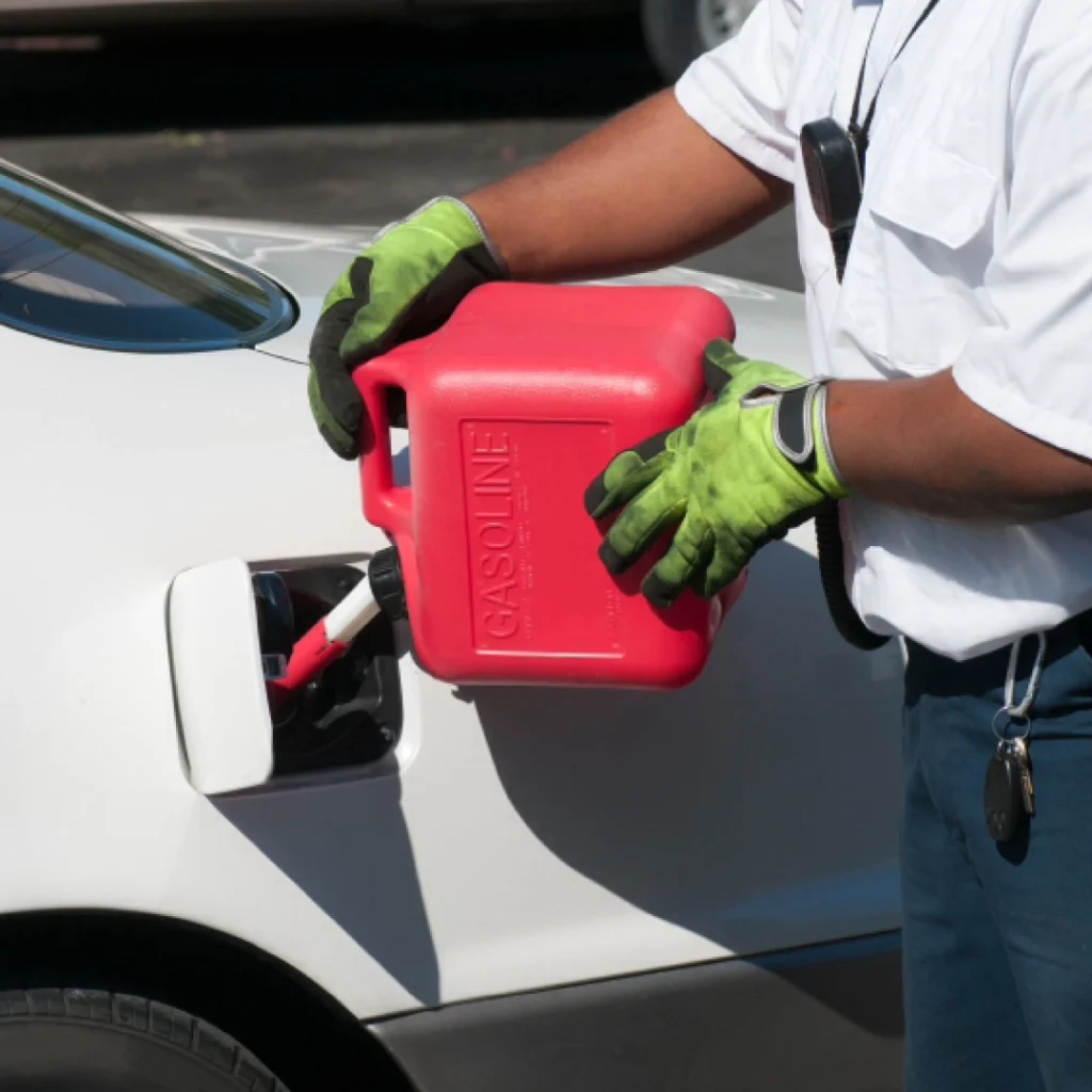 a person holding a gas can to refill a white car in an emergency