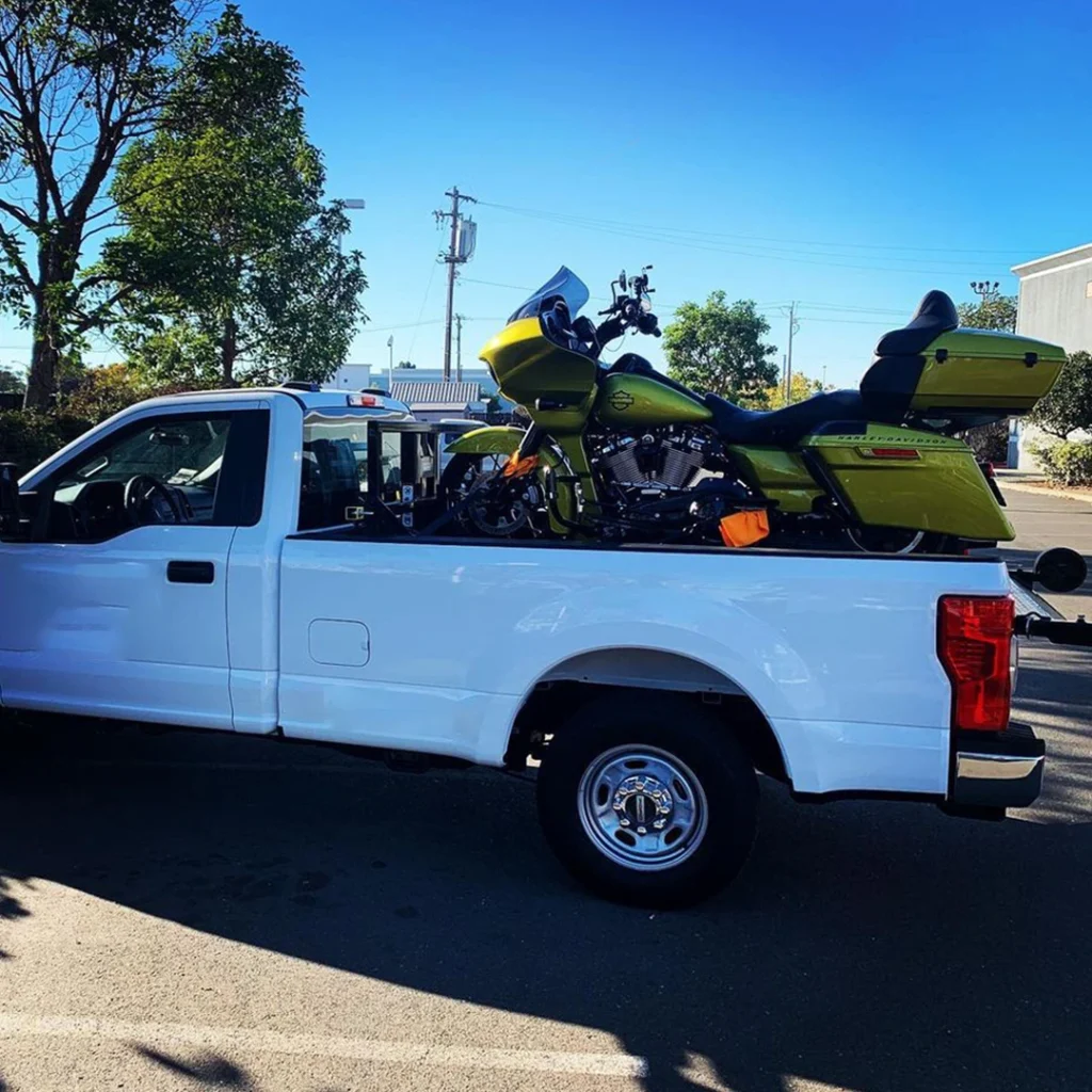 a white truck with a motorcycle on the back