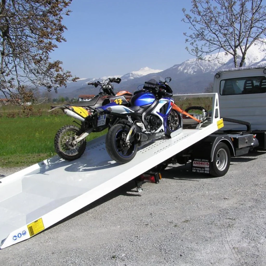 a truck with a flatbed trailer and motorcycles on it