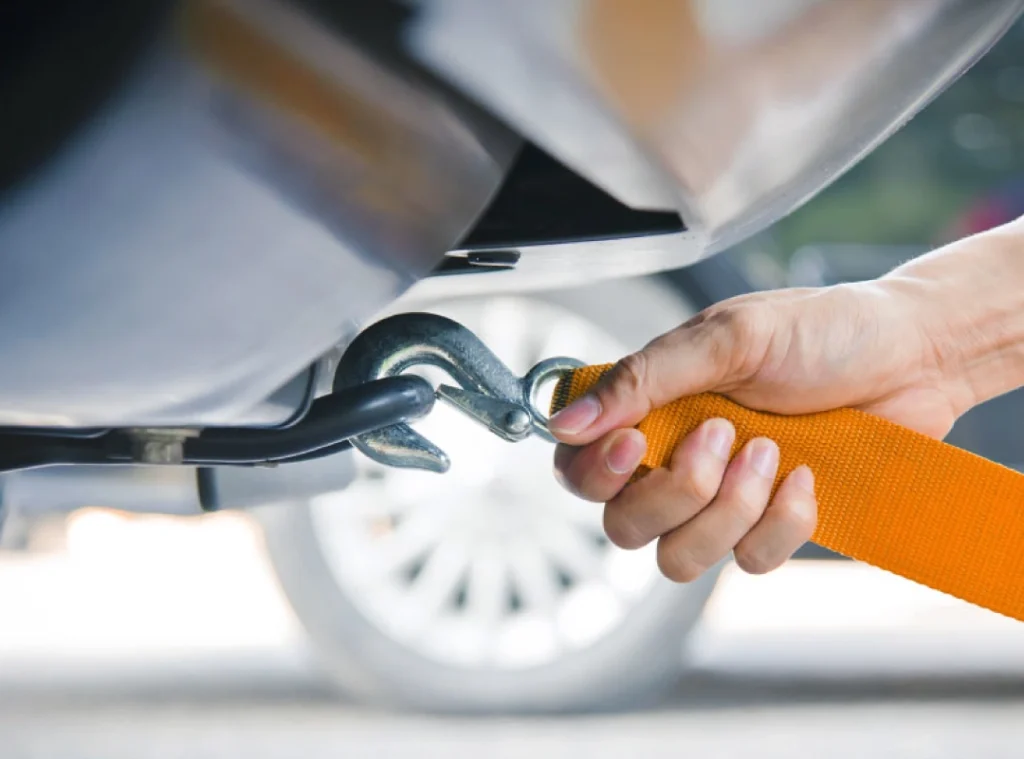 a hand holding a hook to a car